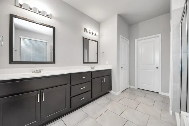 a spacious bathroom with a double vanity sink mirror and