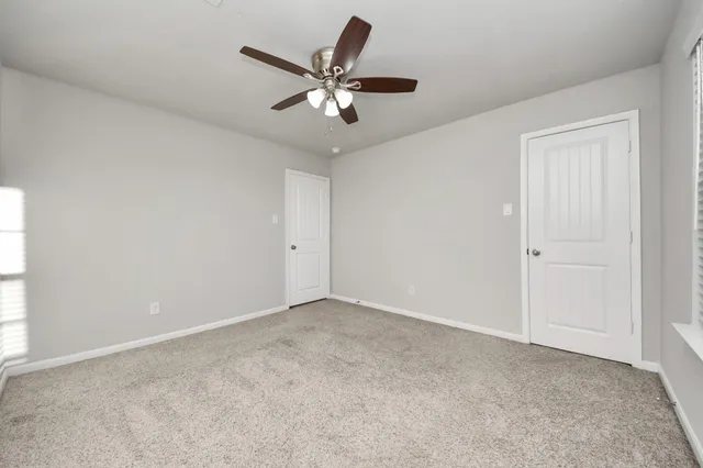 a view of an empty room with a ceiling fan