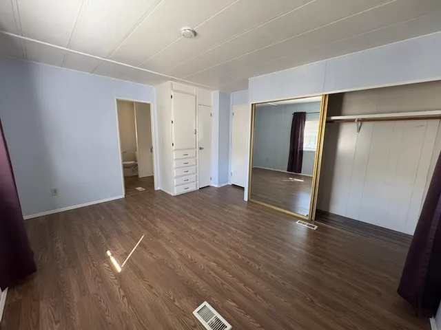 an empty room with wooden floor and closet