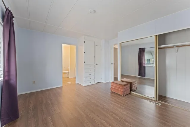 a view of empty room with wooden floor and window