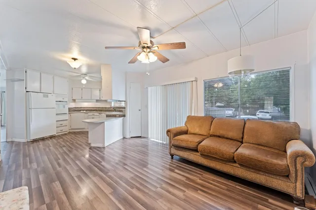 a living room with furniture and a large window with kitchen view
