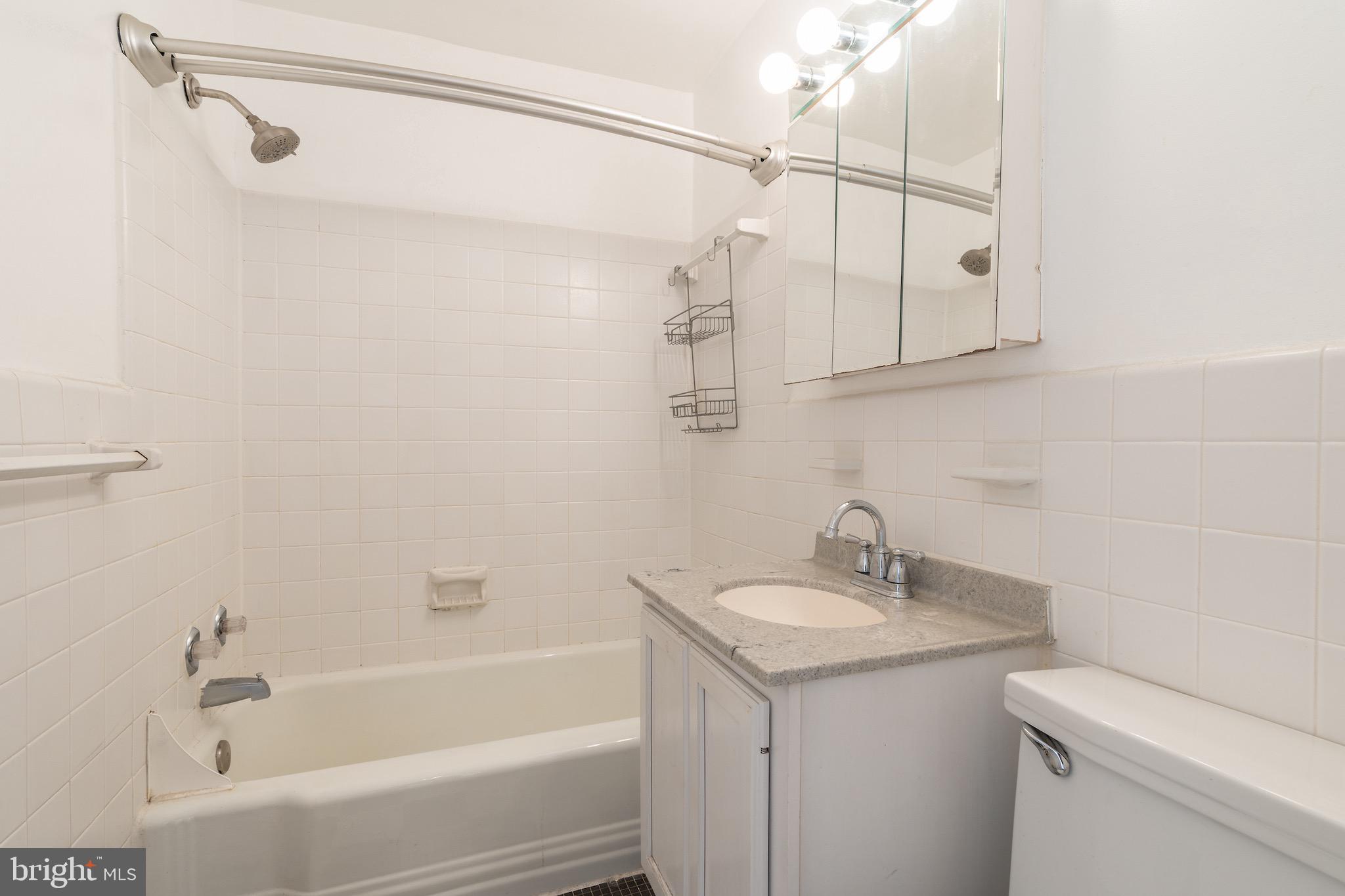 10423 Montrose Avenue, Unit 10423 Bethesda, MD 20814 - Photo 16 of 22 a bathroom with a sink a mirror and a shower