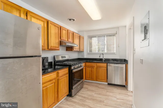 a kitchen with stainless steel appliances granite countertop a stove a sink and a refrigerator