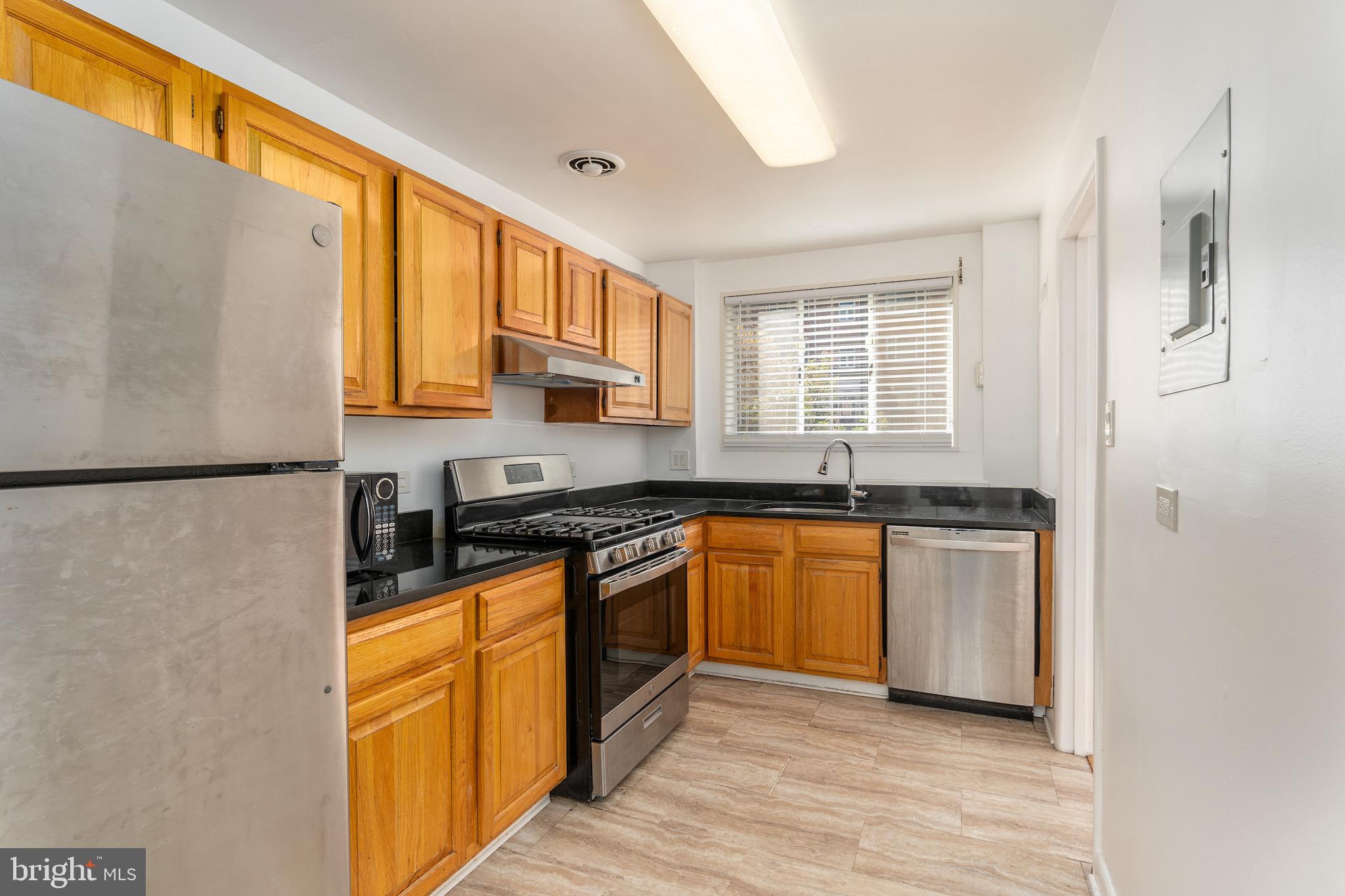 10423 Montrose Avenue, Unit 10423 Bethesda, MD 20814 - Photo 3 of 22 a kitchen with stainless steel appliances granite countertop a stove a sink and a refrigerator