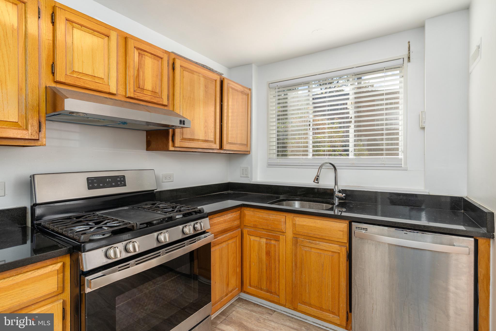 10423 Montrose Avenue, Unit 10423 Bethesda, MD 20814 - Photo 4 of 22 a kitchen with granite countertop cabinets stainless steel appliances a sink and a window