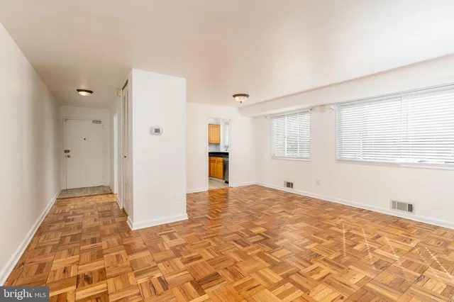 a view of empty room with wooden floor