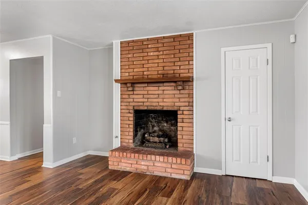 a living room with a fireplace and wooden floor