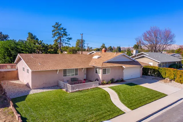 a aerial view of a house with table and chairs under an umbrella