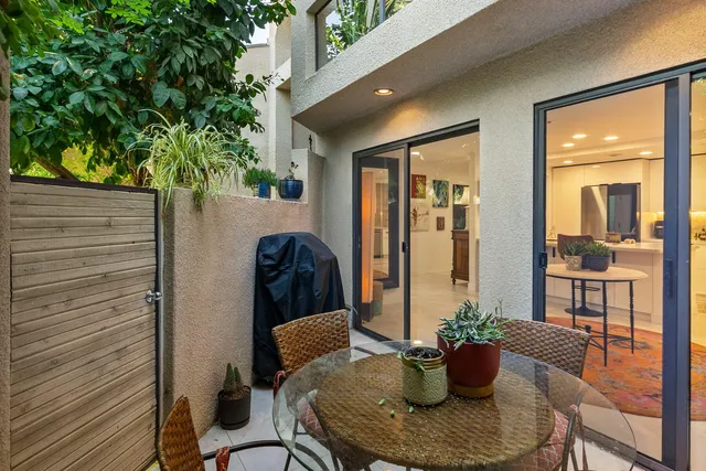 a kitchen with stainless steel appliances kitchen island granite countertop a sink and a view of living room