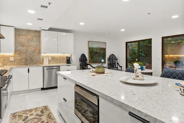 a kitchen with stainless steel appliances kitchen island granite countertop a stove and a sink