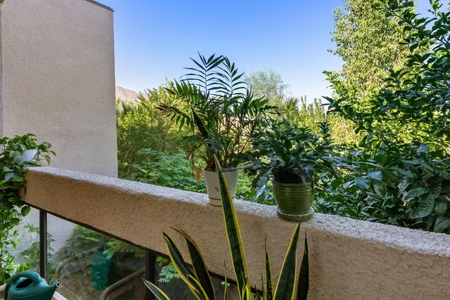 a view of balcony with furniture and garden