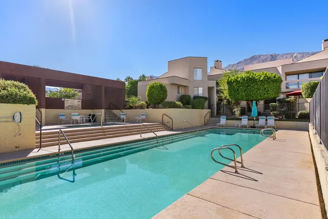 a view of a patio with couches table and chairs with wooden floor and fence