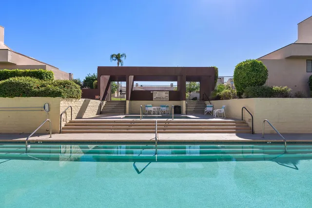 a view of a backyard with swimming pool and sitting area