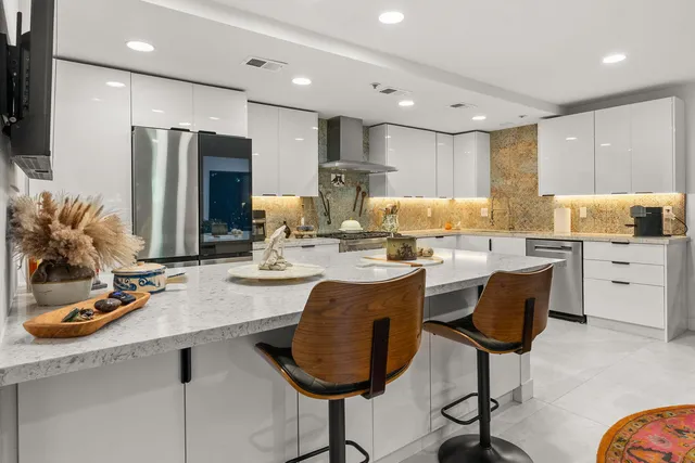 a kitchen with granite countertop white cabinets and stainless steel appliances