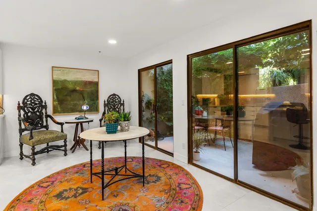 a living room with stainless steel appliances furniture a rug and a flat screen tv