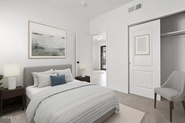 a bedroom with a bed and a painting on the wall