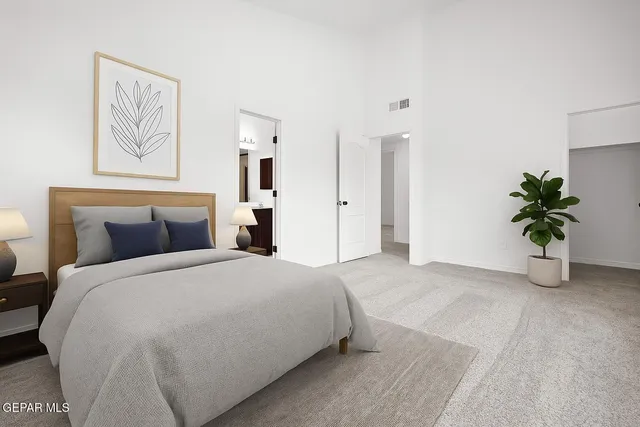 a spacious bedroom with a bed and a potted plant