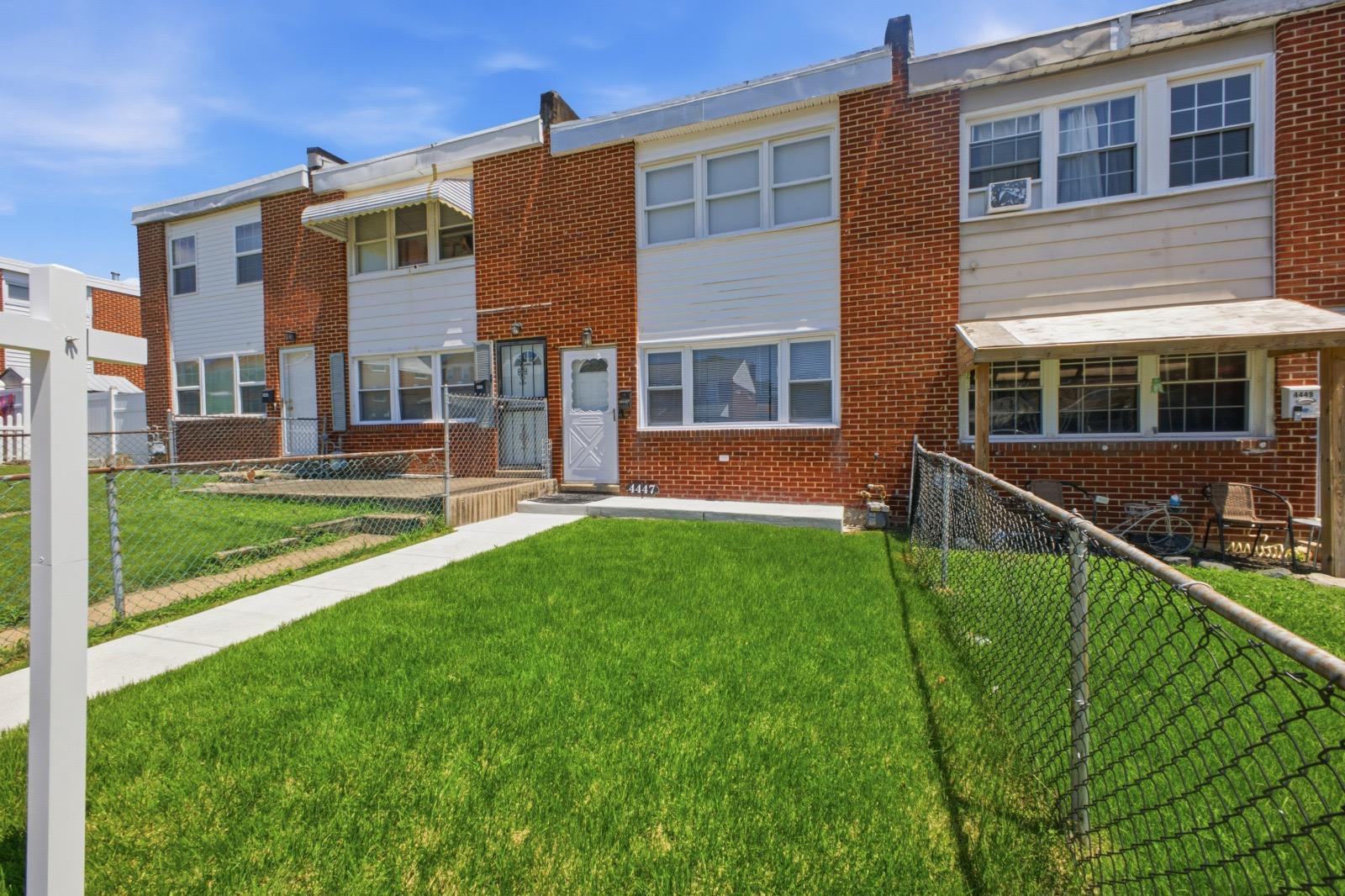 Charming brick townhouse with lush lawn.