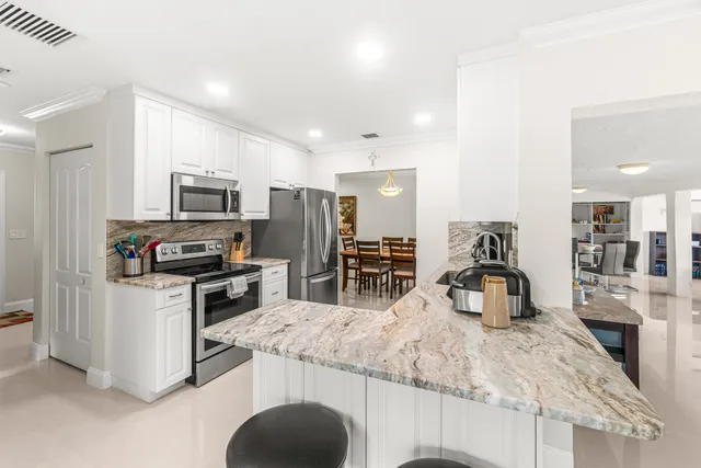 a kitchen with granite countertop a sink stainless steel appliances and counter space