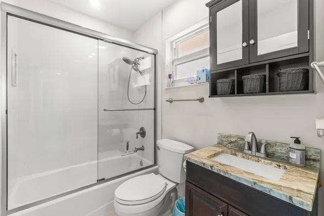 a bathroom with a granite countertop sink toilet and shower