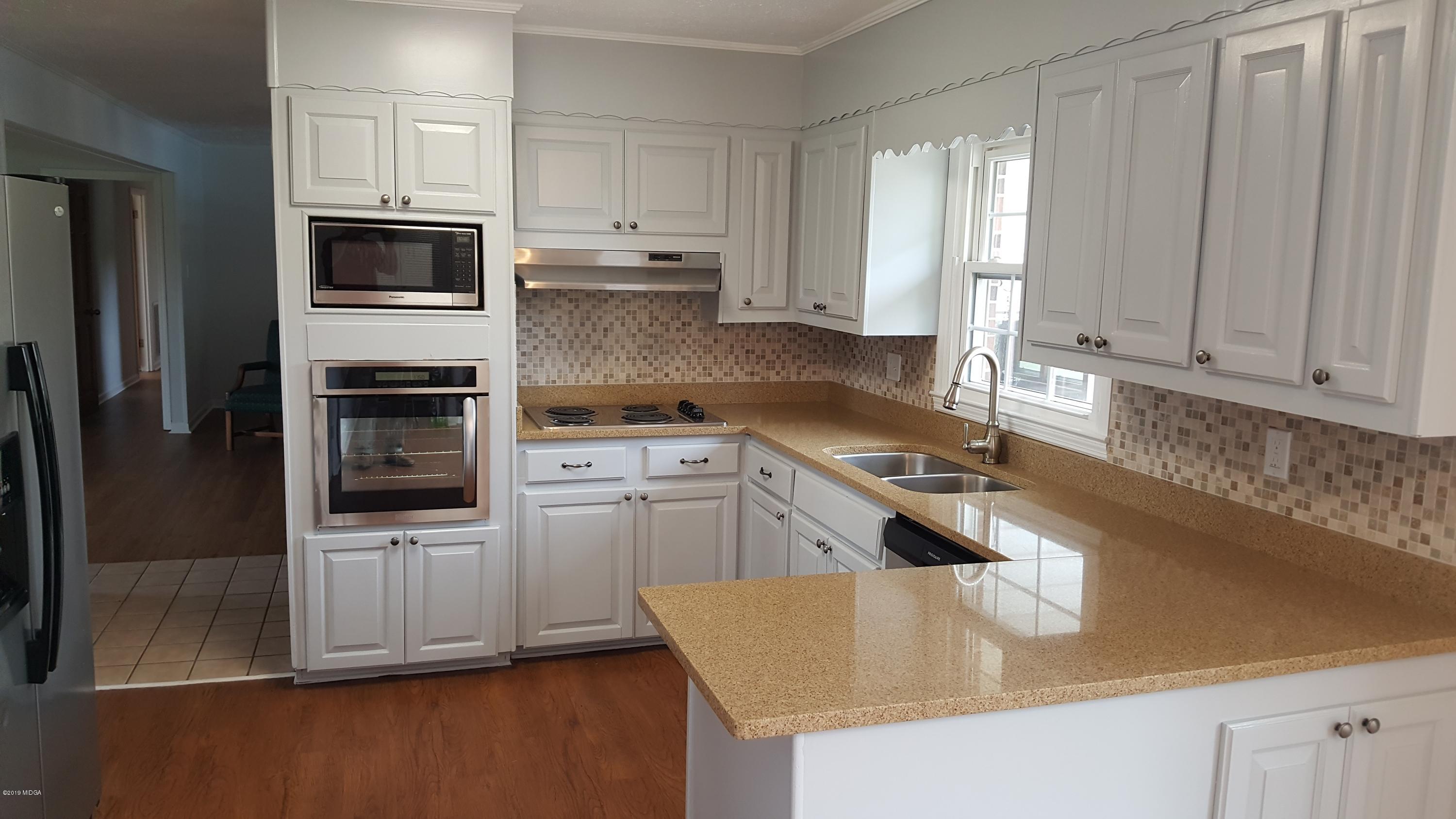 5545 Marshall Mill Road Lizella, GA 31052 - Photo 2 of 12 a kitchen with stainless steel appliances granite countertop a sink a stove and a refrigerator