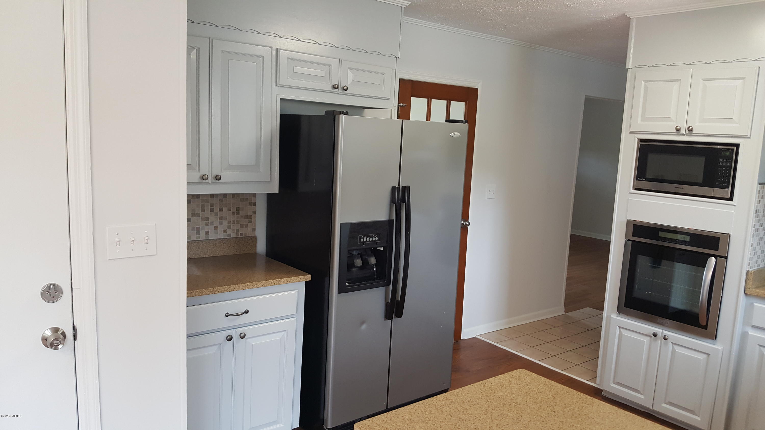 5545 Marshall Mill Road Lizella, GA 31052 - Photo 3 of 12 a kitchen with stainless steel appliances a refrigerator a stove and cabinets
