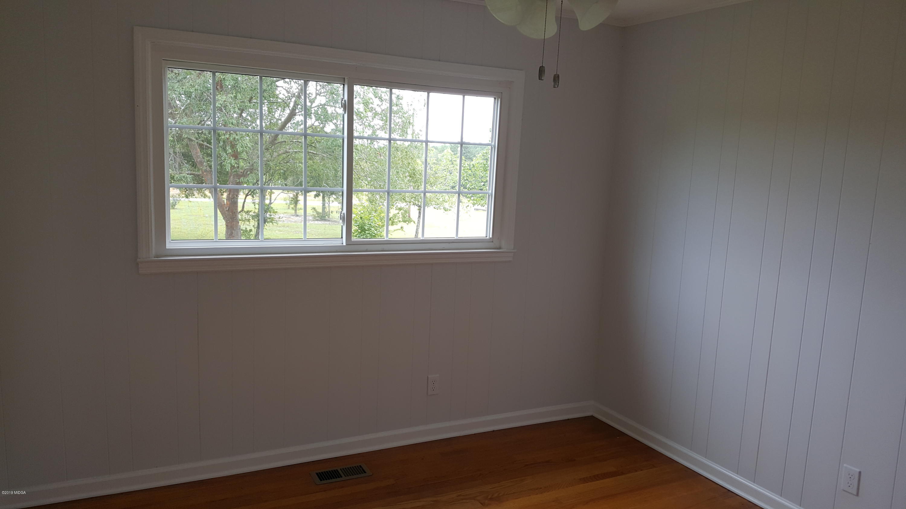 5545 Marshall Mill Road Lizella, GA 31052 - Photo 7 of 12 an empty room with wooden floor and windows