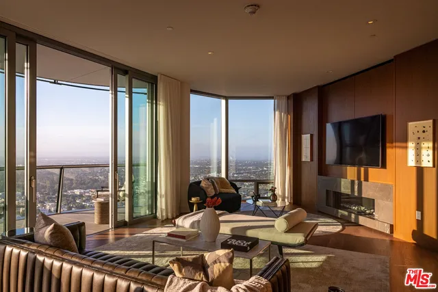 a living room with furniture floor to ceiling window and a flat screen tv