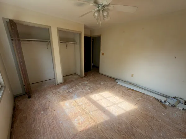 an empty room with closet and a chandelier fan
