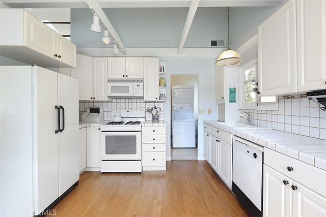 a kitchen with white cabinets and white appliances