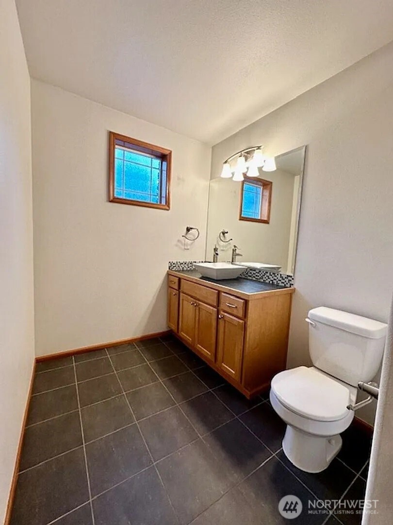 2013 Northeast 27th Street Renton, WA 98056 - Photo 14 of 25 a bathroom with a toilet a sink and mirror