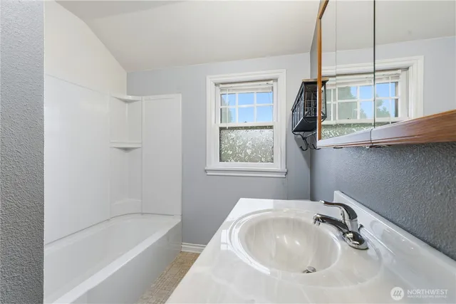 a bathroom with a sink a bathtub and window