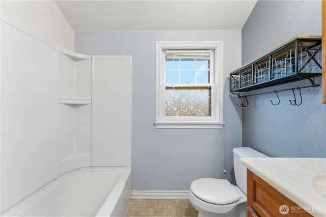 a white toilet sitting next to a bath tub