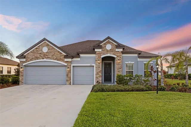 a front view of a house with a garden and trees
