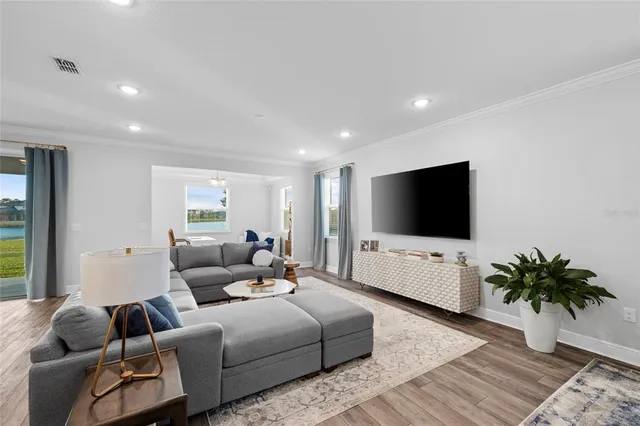 a living room with furniture wooden floor and a flat screen tv
