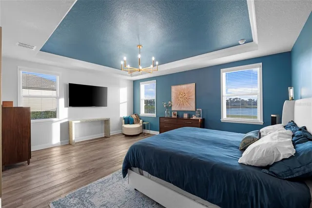 a spacious bedroom with a bed and a flat screen tv