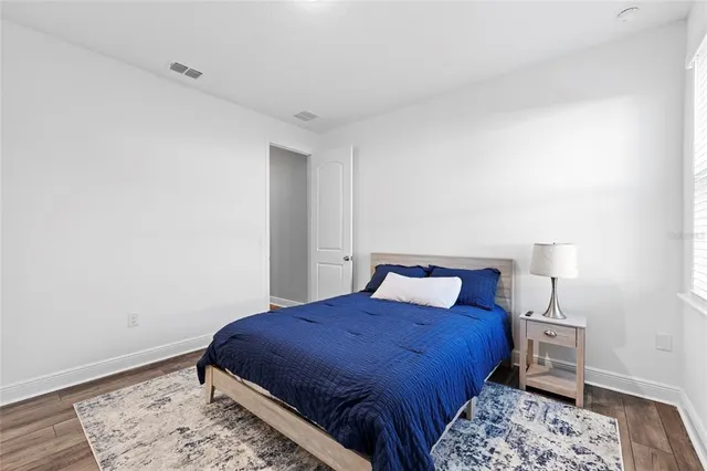 a bedroom with a bed desk and a window