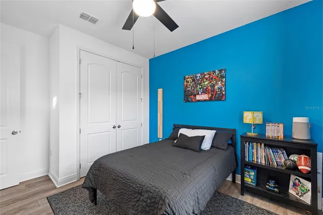 a bedroom with a bed and wooden floor