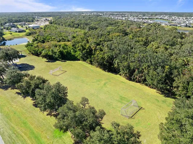 an aerial view of a residential houses with outdoor space and lake view