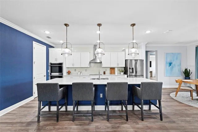 a kitchen with kitchen island a refrigerator a stove a sink and a wooden floors