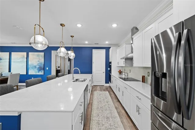 a kitchen with stainless steel appliances white cabinets and a refrigerator