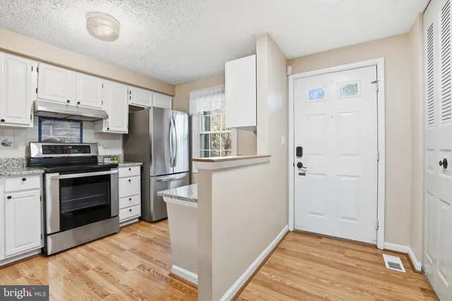 a kitchen with a refrigerator stove and wooden cabinets