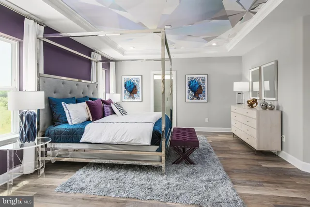 a bedroom with a bed wooden floor and window