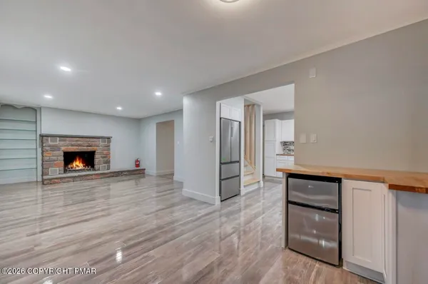 a view of empty room with wooden floor and fireplace