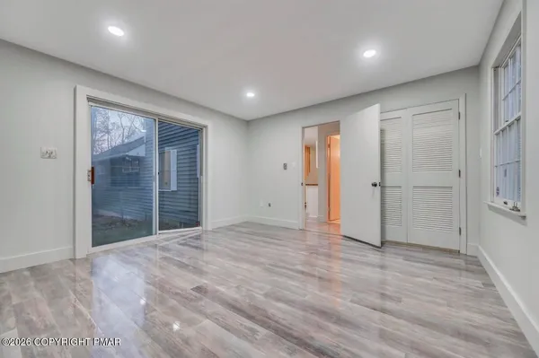 an empty room with wooden floor and window