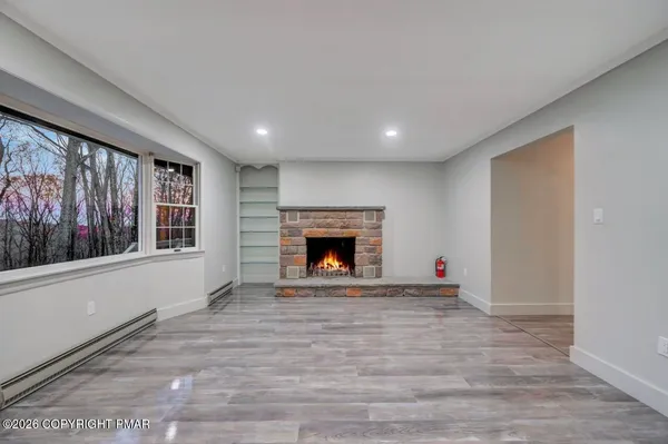 a view of an empty room with a fireplace and a window