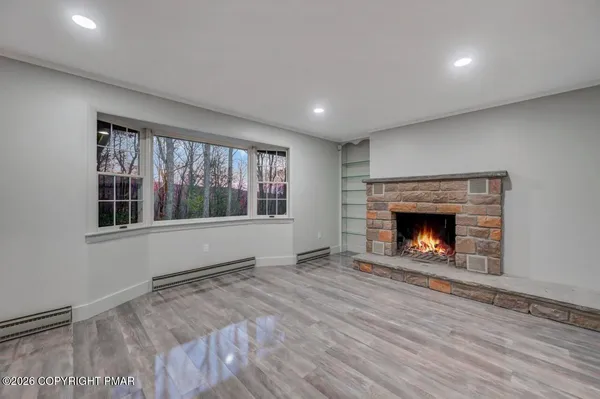 a view of an empty room with a window and fireplace