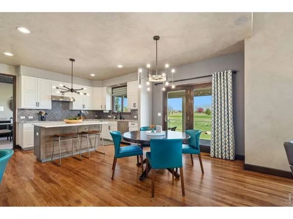 a open dining room with kitchen island stainless steel appliances furniture a chandelier and kitchen view