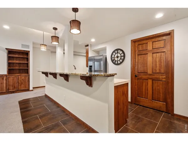a living room with furniture a clock and a view of kitchen