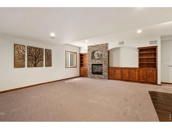 a view of an empty room with furniture and a kitchen